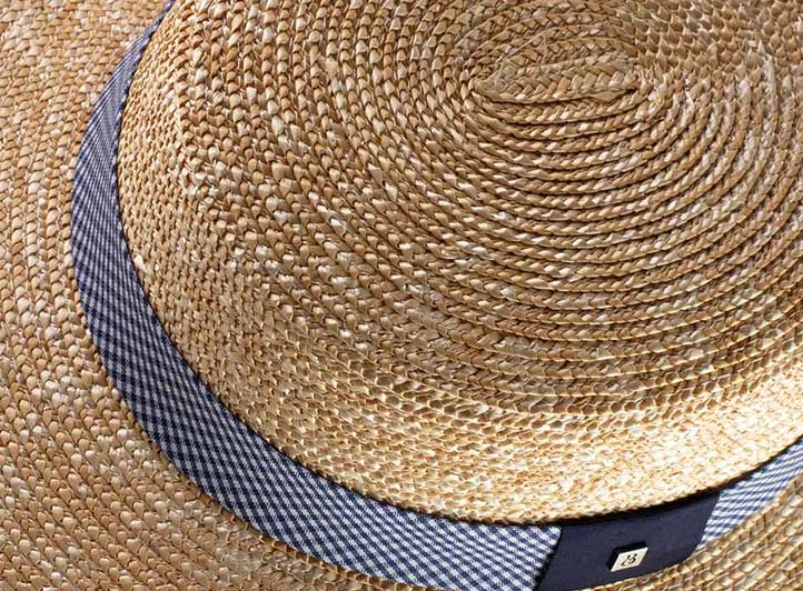 Primer plano de una trenza en espiral cosida en un sombrero canotier