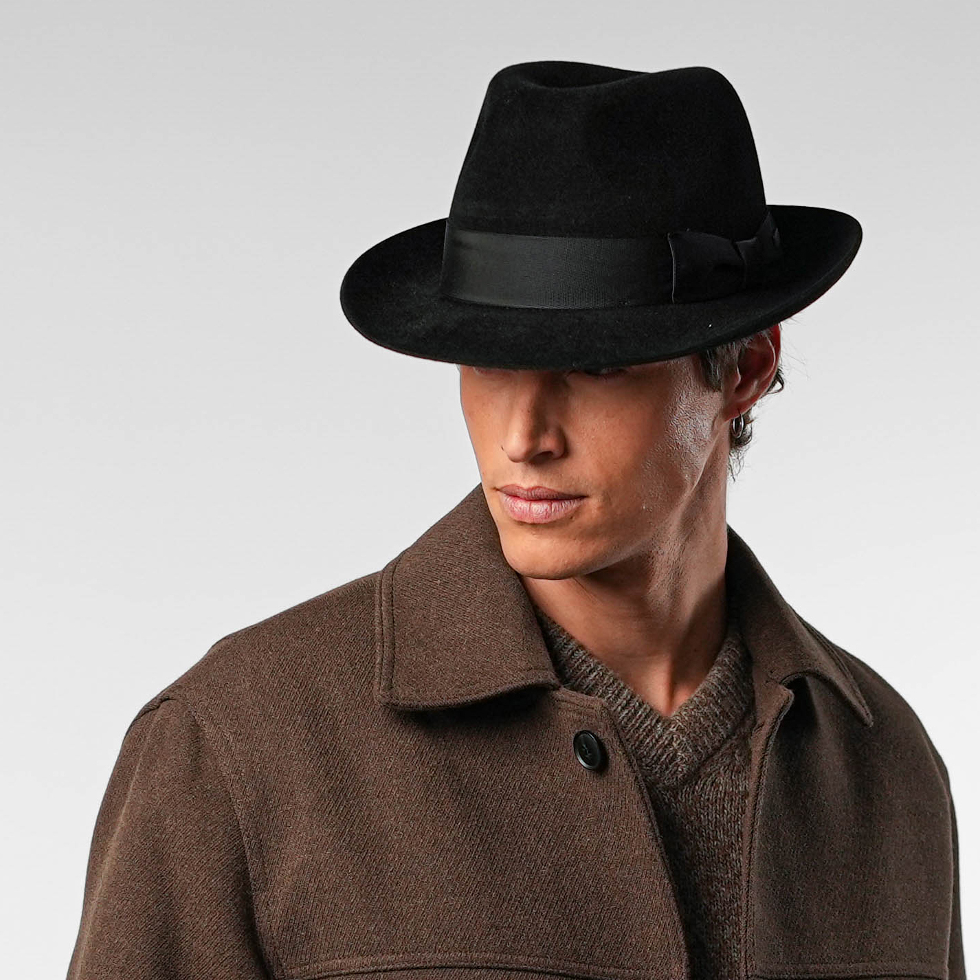 Fedora inclinado hacia delante, aire misterioso